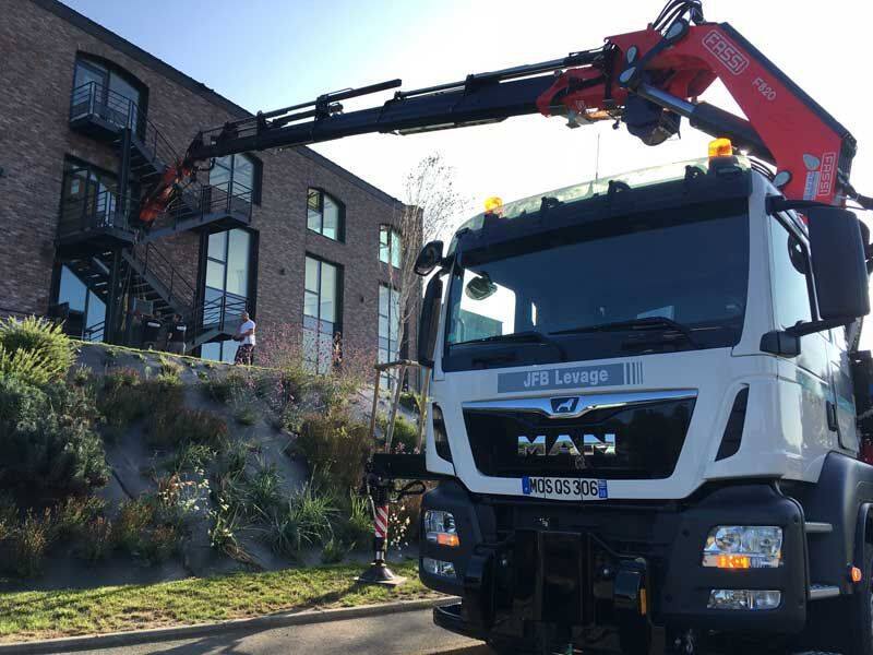 Un camion avec grue pour transporter et poser les matériaux sur